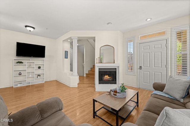 489 W Summerfield Cir, Anaheim, CA 92802 - living room featuring ornate columns, plenty of natural light, light wood-style flooring, a warm lit fireplace, and recessed lighting