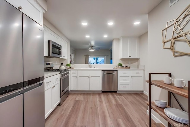 11033 Scripps Ranch Blvd, San Diego, CA 92131 - kitchen with appliances with stainless steel finishes, ceiling fan, light countertops, light wood-type flooring, and white cabinetry