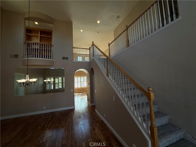 4125 Sattui Ct, Merced, CA 95348 - stairs with arched walkways, wood-type flooring, a high ceiling, a chandelier, and recessed lighting