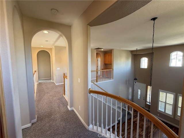 4125 Sattui Ct, Merced, CA 95348 - hallway featuring an upstairs landing, dark carpet, and arched walkways