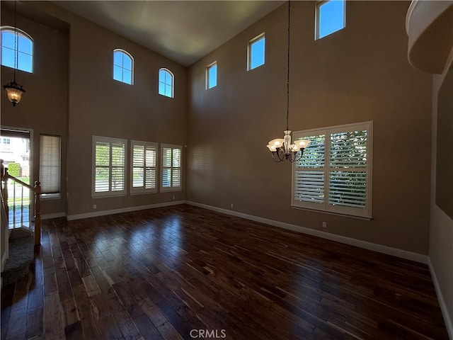 4125 Sattui Ct, Merced, CA 95348 - unfurnished living room featuring dark wood finished floors, a chandelier, and a high ceiling