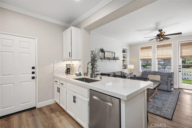 42 Livingston Pl, Ladera Ranch, CA 92694 - kitchen with stainless steel dishwasher, a peninsula, wood finished floors, a ceiling fan, and crown molding