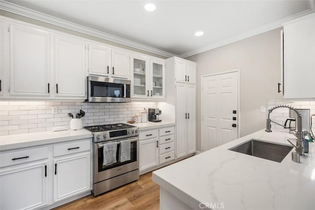 42 Livingston Pl, Ladera Ranch, CA 92694 - kitchen with appliances with stainless steel finishes, white cabinets, backsplash, crown molding, and light stone countertops