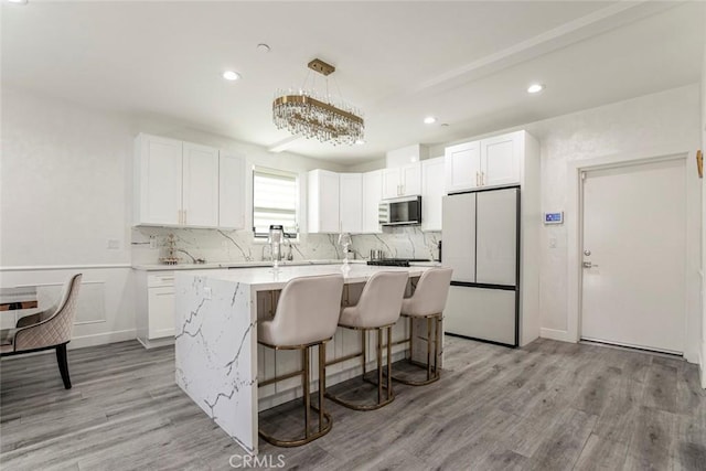9124 N Nilo Ln, Panorama City, CA 91402 - kitchen with freestanding refrigerator, white cabinets, light wood-type flooring, and recessed lighting