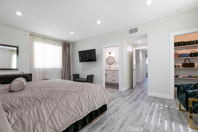 9124 N Nilo Ln, Panorama City, CA 91402 - bedroom featuring light wood finished floors, a walk in closet, recessed lighting, and connected bathroom