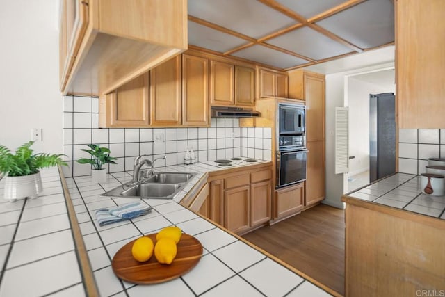 3531 Columbia St, San Diego, CA 92103 - kitchen with appliances with stainless steel finishes, tile counters, under cabinet range hood, backsplash, and dark wood finished floors