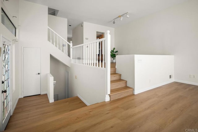 3531 Columbia St, San Diego, CA 92103 - stairs featuring wood finished floors, a towering ceiling, and rail lighting