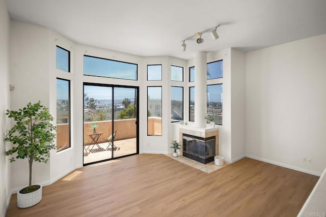 3531 Columbia St, San Diego, CA 92103 - unfurnished living room with light wood-type flooring, a tiled fireplace, and track lighting