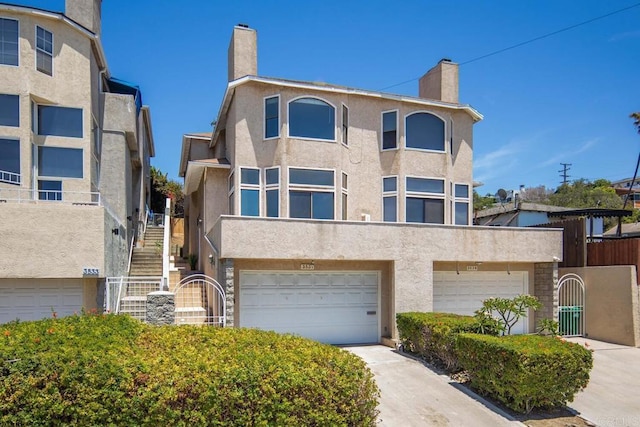 3531 Columbia St, San Diego, CA 92103 - view of front of house featuring stucco siding, a chimney, an attached garage, and driveway