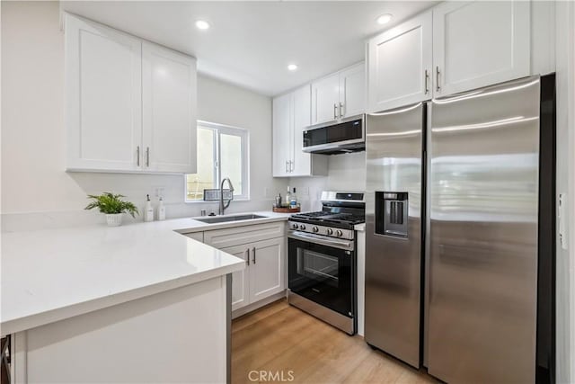 11722 Avon Way Unit 103, Los Angeles, CA 90066 - kitchen with appliances with stainless steel finishes, a peninsula, white cabinetry, light countertops, and recessed lighting
