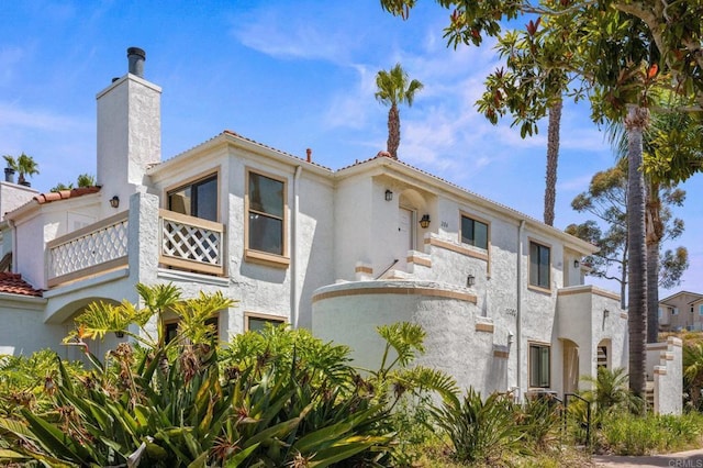 13292 Salmon River Rd Unit 204, San Diego, CA 92129 - view of property exterior with a balcony, stucco siding, and a chimney