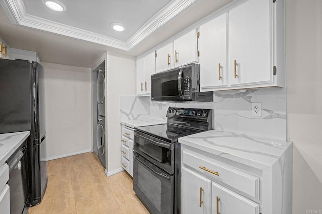 13292 Salmon River Rd Unit 204, San Diego, CA 92129 - kitchen with black appliances, stacked washing machine and dryer, white cabinetry, light stone counters, and ornamental molding