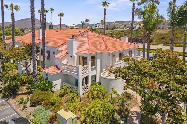 13292 Salmon River Rd Unit 204, San Diego, CA 92129 - rear view of house with a chimney, a tiled roof, a balcony, stucco siding, and a mountain view