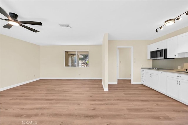 3777 N Arrowhead Ave, San Bernardino, CA 92405 - kitchen featuring white cabinets, light wood-style flooring, ceiling fan, black electric cooktop, and open floor plan