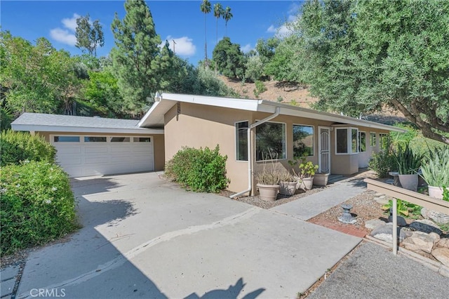 3777 N Arrowhead Ave, San Bernardino, CA 92405 - view of front of house featuring a garage, stucco siding, and driveway