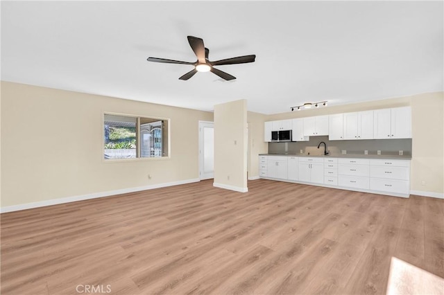 3777 N Arrowhead Ave, San Bernardino, CA 92405 - unfurnished living room featuring a ceiling fan and light wood finished floors