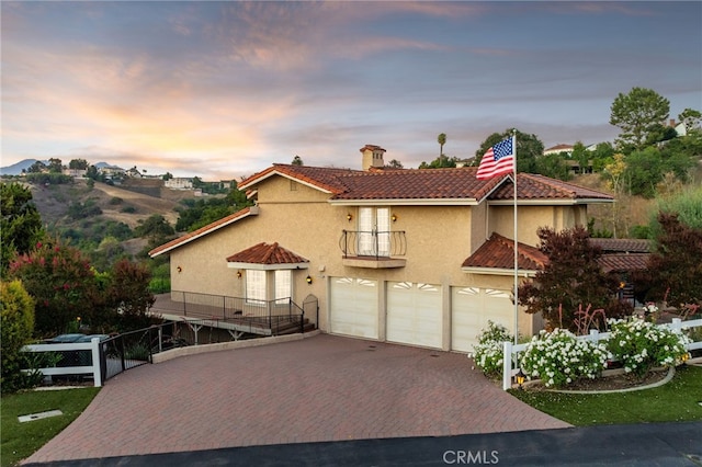 23511 Mirage Ln, Diamond Bar, CA 91765 - mediterranean / spanish-style house with a balcony, decorative driveway, stucco siding, a chimney, and an attached garage