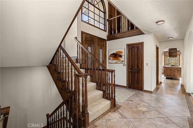 23511 Mirage Ln, Diamond Bar, CA 91765 - staircase featuring a textured ceiling and arched walkways
