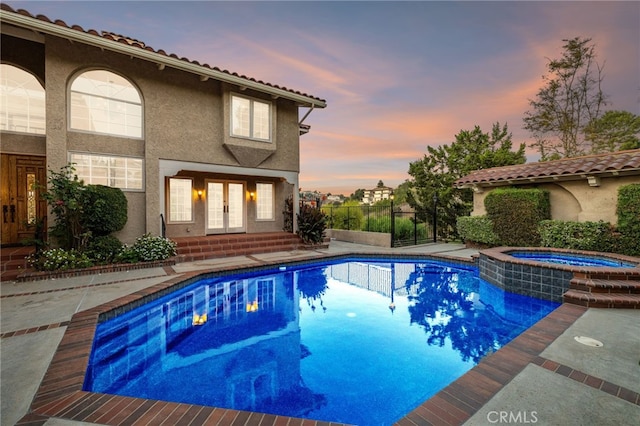 23511 Mirage Ln, Diamond Bar, CA 91765 - pool at dusk featuring french doors, a pool with connected hot tub, and entry steps