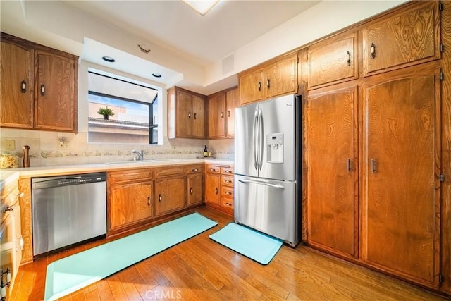 2008 S Bentley Ave Unit 5, Los Angeles, CA 90025 - kitchen featuring stainless steel appliances, brown cabinets, light wood-style flooring, and light countertops