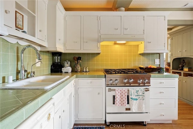 1521 5th St, Los Osos, CA 93402 - kitchen with range with gas stovetop, tile counters, white cabinets, and tasteful backsplash