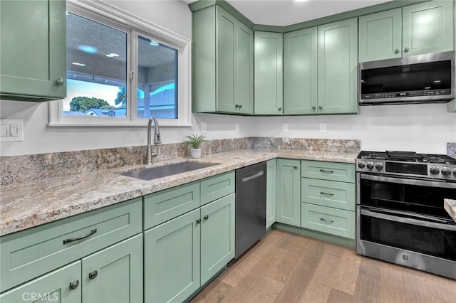 6721 E Coralite St, Long Beach, CA 90808 - kitchen featuring green cabinets, appliances with stainless steel finishes, wood finished floors, and light stone countertops
