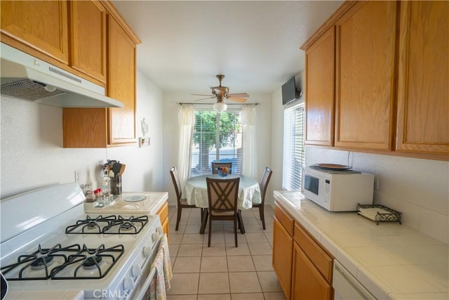 19078 Stoddard Way, Apple Valley, CA 92308 - kitchen with white appliances, tile countertops, under cabinet range hood, a ceiling fan, and light tile patterned floors