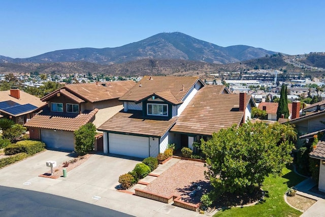 10323 Pine Grove St, Spring Valley, CA 91978 - view of front of property with a mountain view, concrete driveway, an attached garage, and a tiled roof