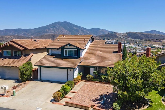 10323 Pine Grove St, Spring Valley, CA 91978 - view of front of home with an attached garage, driveway, a mountain view, a tiled roof, and a chimney