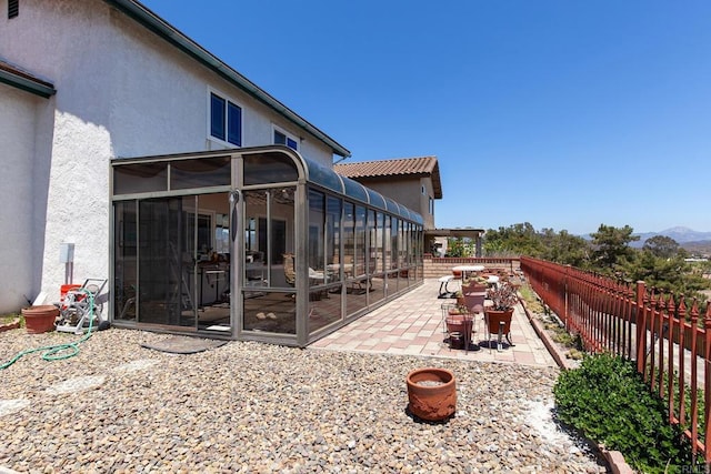 10323 Pine Grove St, Spring Valley, CA 91978 - view of property exterior featuring a sunroom, stucco siding, a patio area, a fenced backyard, and a mountain view
