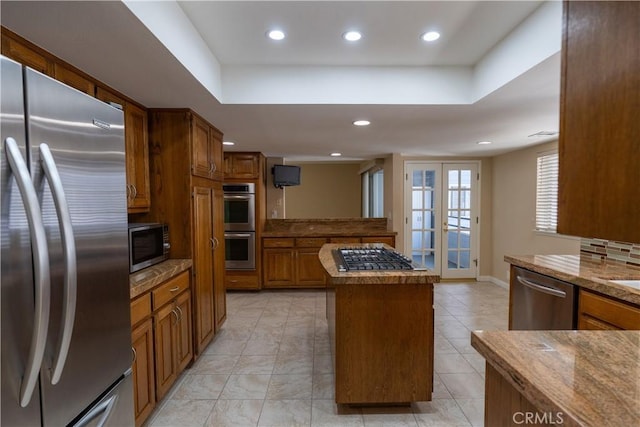 23169 Mulholland Dr Unit 3, Woodland Hills, CA 91364 - kitchen with stainless steel appliances, a center island, brown cabinetry, recessed lighting, and a tray ceiling