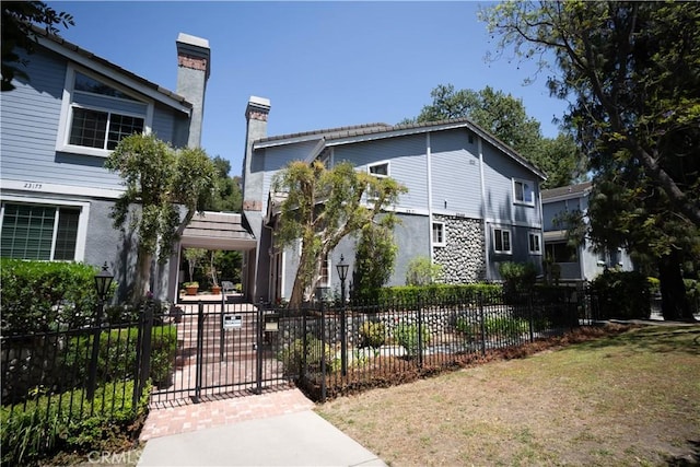 23169 Mulholland Dr Unit 3, Woodland Hills, CA 91364 - view of front facade with a fenced front yard, a chimney, and stucco siding
