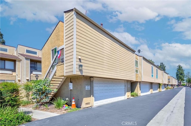 5473 Twin Lakes Dr, Cypress, CA 90630 - view of building exterior with stairway, driveway, and a garage