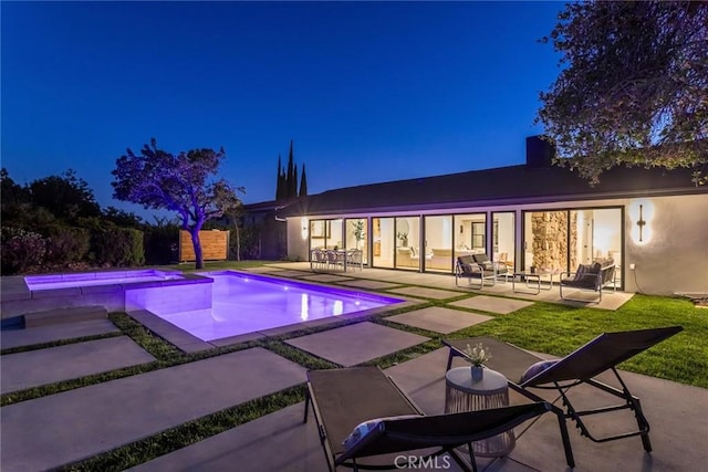 12350 Mclennan Ave, Granada Hills, CA 91344 - pool at night with a patio area, a pool with connected hot tub, and outdoor lounge area