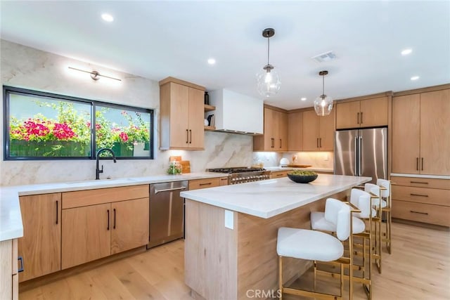 12350 Mclennan Ave, Granada Hills, CA 91344 - kitchen with appliances with stainless steel finishes, light wood-style flooring, light brown cabinets, a breakfast bar area, and open shelves