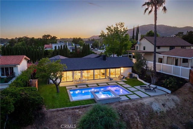12350 Mclennan Ave, Granada Hills, CA 91344 - back of property with a patio area, a lawn, a mountain view, and a pool with connected hot tub