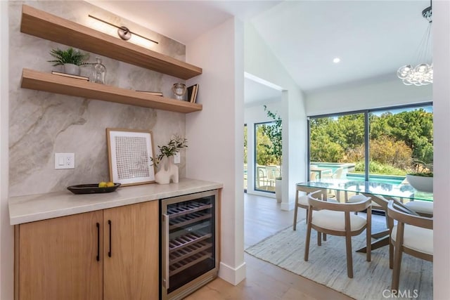 12350 Mclennan Ave, Granada Hills, CA 91344 - indoor bar featuring wine cooler, lofted ceiling, light wood-type flooring, and a chandelier