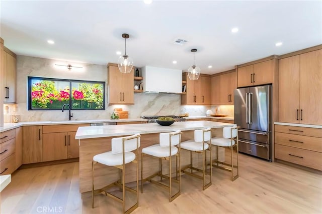 12350 Mclennan Ave, Granada Hills, CA 91344 - kitchen with high quality fridge, light wood-style floors, light countertops, backsplash, and a breakfast bar