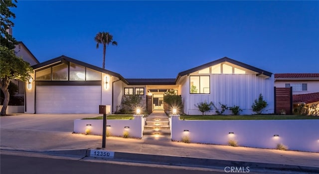 12350 Mclennan Ave, Granada Hills, CA 91344 - view of front of house with concrete driveway, an attached garage, and board and batten siding