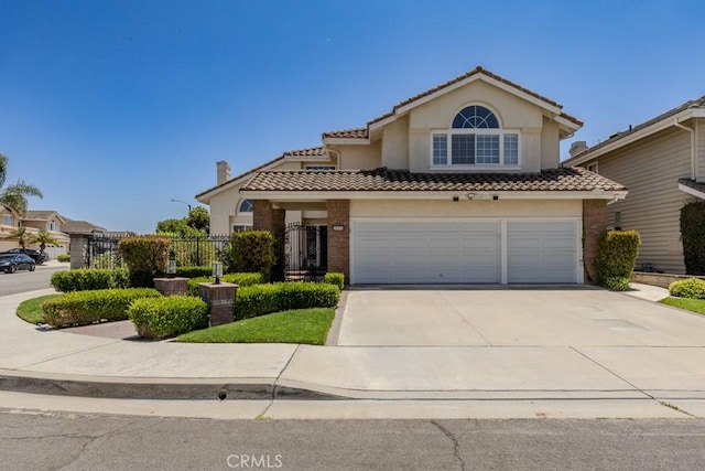 4330 E Cornwall Ave, Orange, CA 92867 - view of front of property featuring a tile roof, driveway, brick siding, and a garage