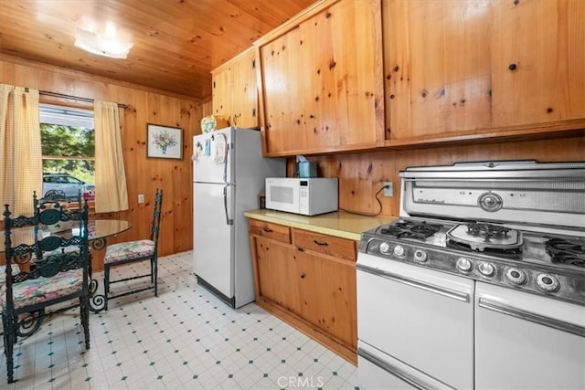 115 Lagunita Ln, Big Bear Lake, CA 92315 - kitchen with white appliances, light flooring, wooden ceiling, light countertops, and wood walls