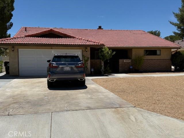 15163 Tournament Dr, Helendale, CA 92342 - single story home featuring concrete driveway, a tile roof, an attached garage, and stucco siding