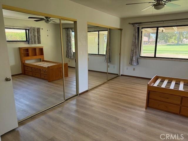 15163 Tournament Dr, Helendale, CA 92342 - bedroom featuring two closets, multiple windows, and wood finished floors