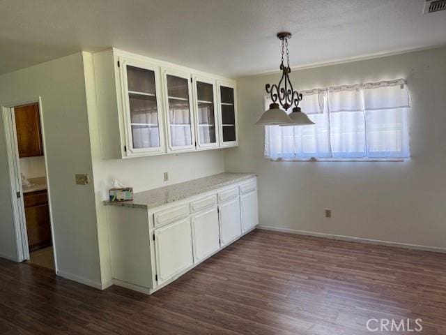 15163 Tournament Dr, Helendale, CA 92342 - kitchen with dark wood-type flooring, glass insert cabinets, white cabinetry, and pendant lighting