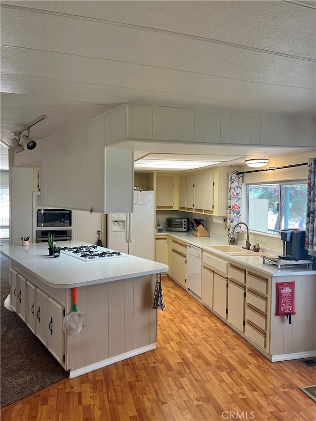 38150 Sumac Ln, Squaw Valley, CA 93675 - kitchen featuring appliances with stainless steel finishes, light wood-type flooring, light countertops, a kitchen island, and rail lighting