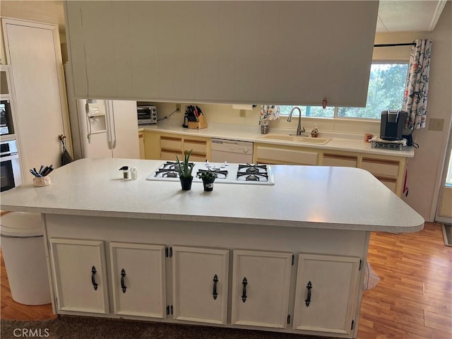 38150 Sumac Ln, Squaw Valley, CA 93675 - kitchen featuring white appliances, light wood-type flooring, light countertops, and white cabinetry