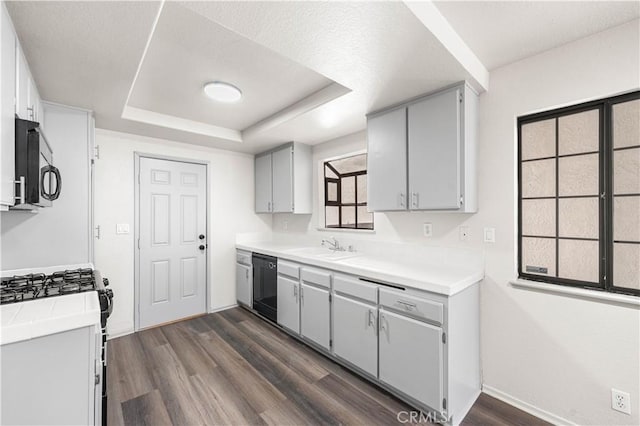 37632 15th St E, Palmdale, CA 93550 - kitchen featuring stainless steel microwave, black dishwasher, dark wood finished floors, a tray ceiling, and range with gas stovetop