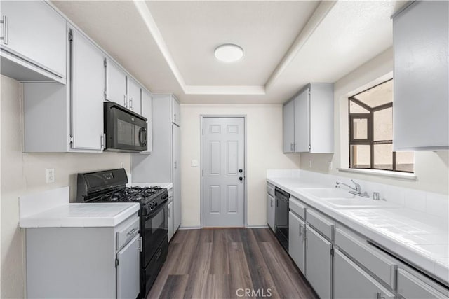 37632 15th St E, Palmdale, CA 93550 - kitchen with black appliances, tile counters, dark wood-style floors, and a tray ceiling