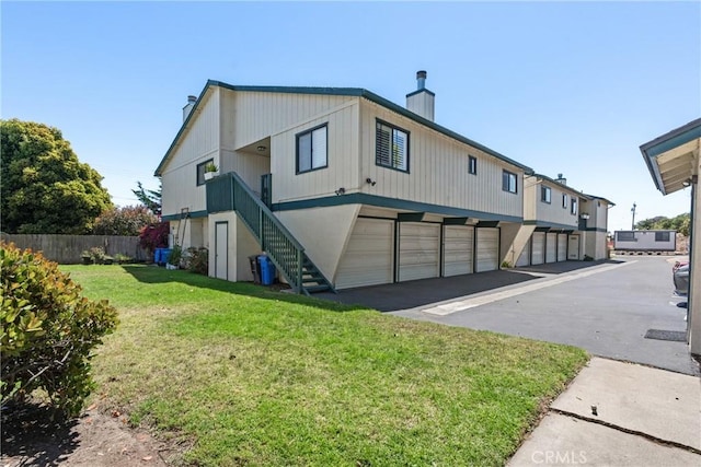 242 N 10th St Unit 242, Grover Beach, CA 93433 - rear view of house featuring a chimney, stairway, asphalt driveway, and an attached garage