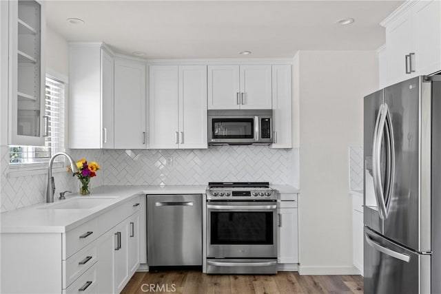 242 N 10th St Unit 242, Grover Beach, CA 93433 - kitchen with appliances with stainless steel finishes, light countertops, white cabinetry, dark wood-style floors, and tasteful backsplash